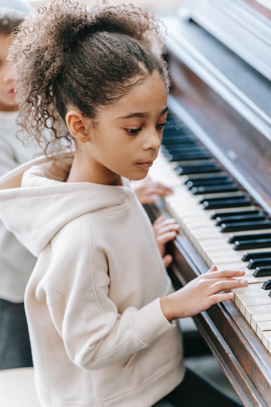 ethnic children playing piano in house