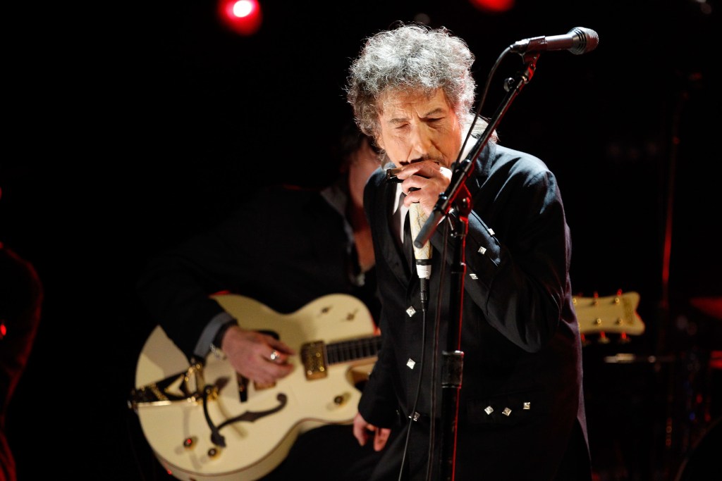 Bob Dylan plays harmonica onstage